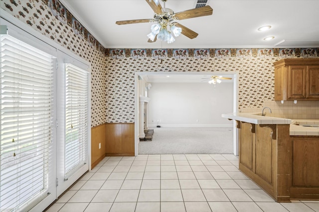 4288 Fm 1652, Grand Saline, TX 75140 - kitchen with crown molding, a wainscoted wall, tile countertops, light tile patterned flooring, and a ceiling fan