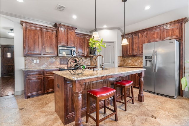 kitchen featuring visible vents, tasteful backsplash, a sink, light stone counters, and stainless steel appliances