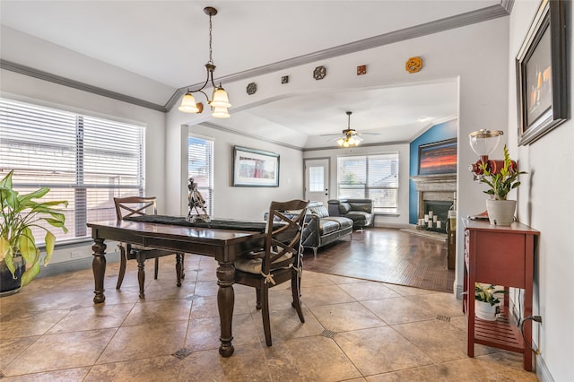 dining room featuring baseboards, ornamental molding, a fireplace, and tile patterned floors
