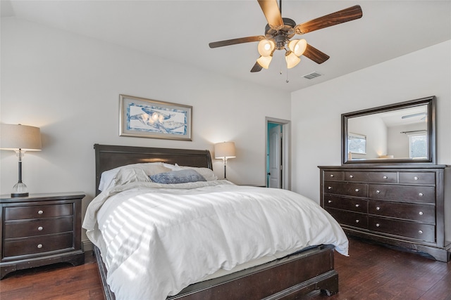 bedroom featuring a ceiling fan, visible vents, and dark wood finished floors
