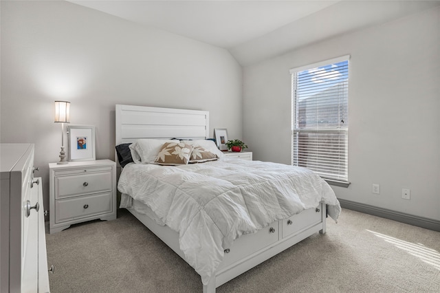 bedroom featuring baseboards, light carpet, and lofted ceiling