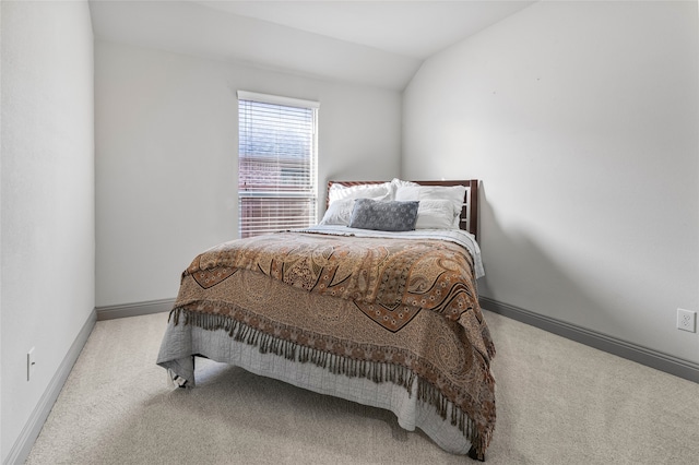 carpeted bedroom featuring baseboards and lofted ceiling