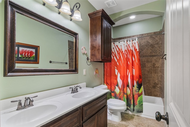 full bathroom with double vanity, toilet, visible vents, and a sink