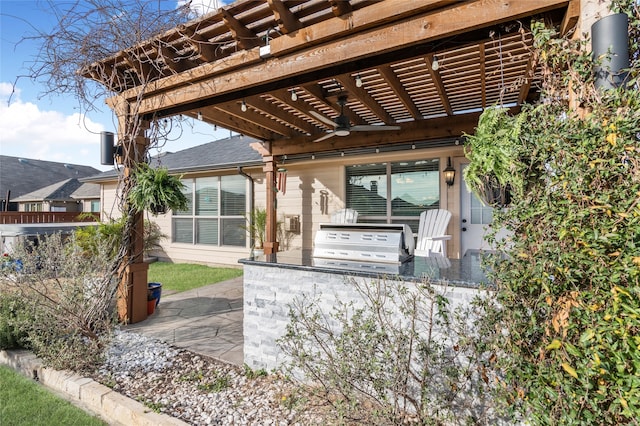 view of patio / terrace with area for grilling, an outdoor kitchen, a ceiling fan, and a pergola