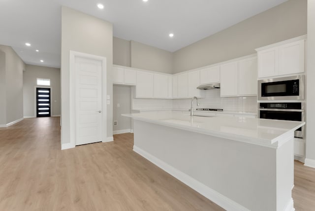 9828 Palermo Ln, Mesquite, TX 75126 - kitchen featuring black microwave, under cabinet range hood, white cabinetry, and oven