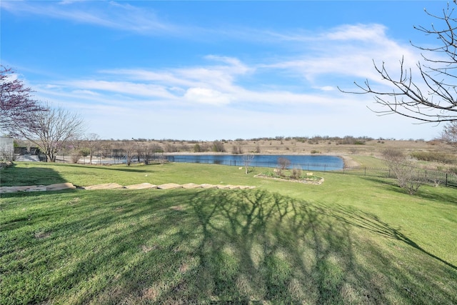 view of yard featuring a water view and fence