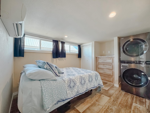 6400 Peninsula Rd, Kerens, TX 75144 - bedroom featuring stacked washer / drying machine, a closet, wood finished floors, and a wall unit AC