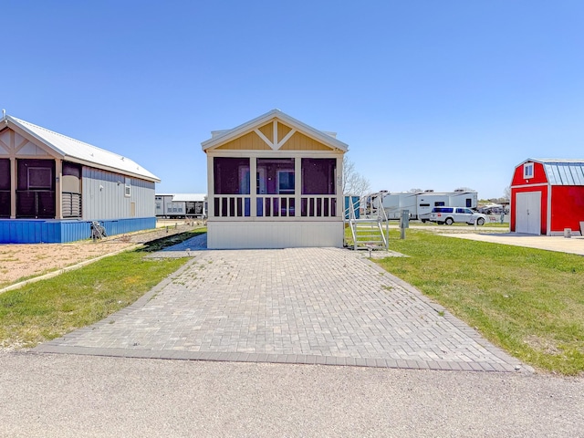 6400 Peninsula Rd, Kerens, TX 75144 - view of front facade with a front lawn, an outbuilding, and a sunroom