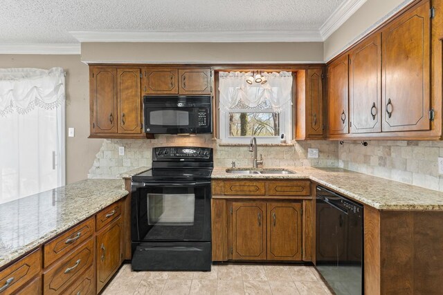 kitchen with tasteful backsplash, crown molding, brown cabinets, black appliances, and a sink