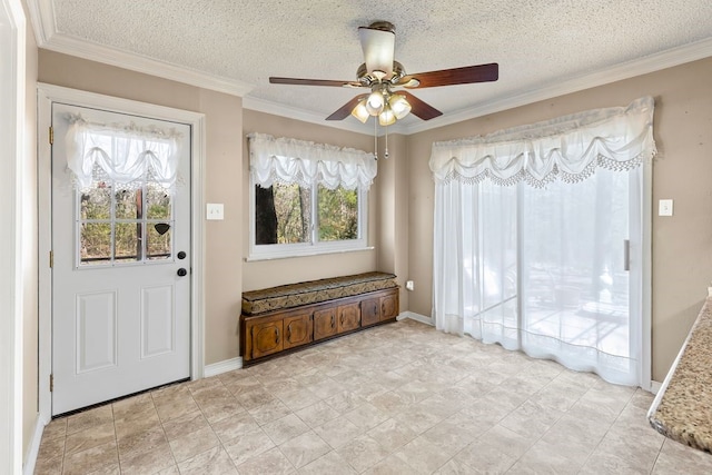 foyer entrance with a textured ceiling, crown molding, baseboards, and ceiling fan