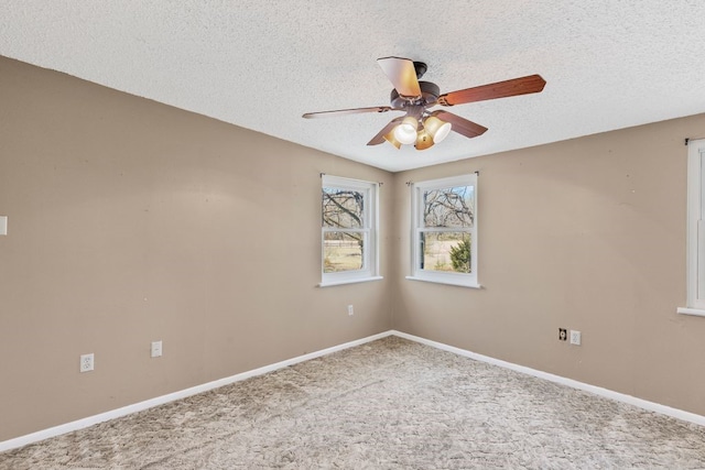 spare room with a ceiling fan, baseboards, carpet floors, and a textured ceiling