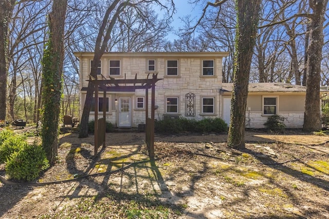 view of front of house featuring a pergola and stone siding