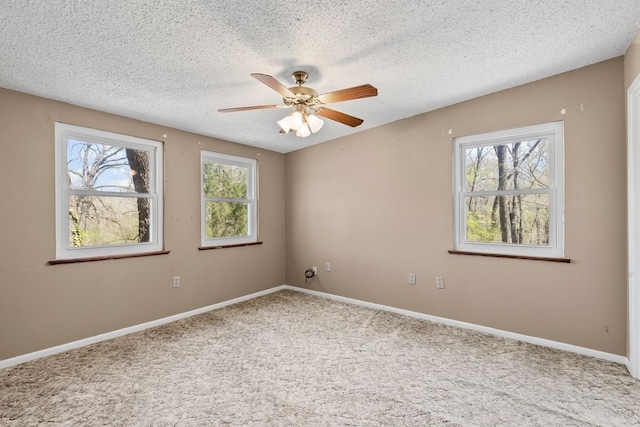 spare room with a wealth of natural light, baseboards, carpet, and ceiling fan