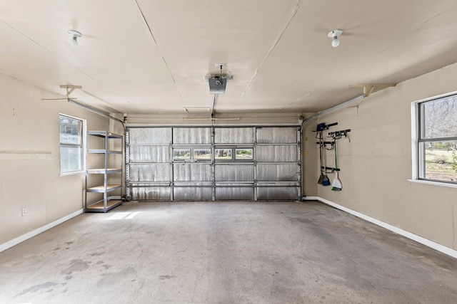 garage featuring a garage door opener and baseboards