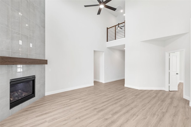 216 Dove Haven Dr, Wylie, TX 75098 - unfurnished living room with a towering ceiling, a ceiling fan, wood finished floors, baseboards, and a fireplace