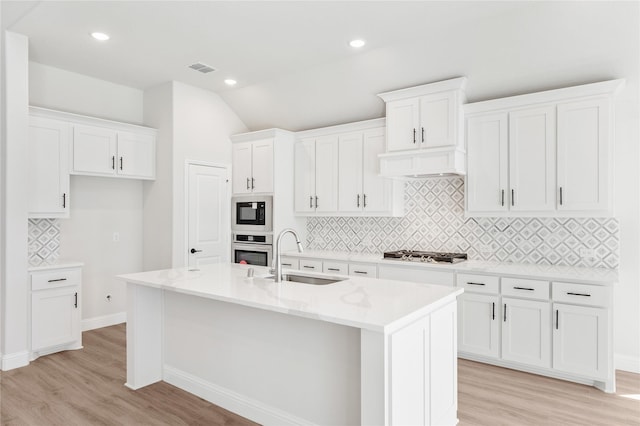 216 Dove Haven Dr, Wylie, TX 75098 - kitchen with stainless steel appliances, a sink, light wood finished floors, tasteful backsplash, and white cabinets