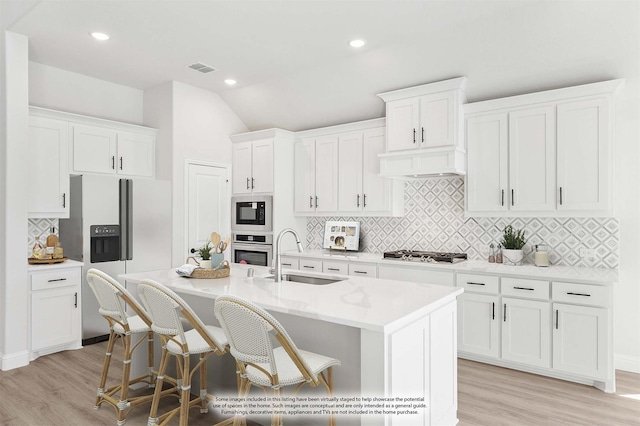216 Dove Haven Dr, Wylie, TX 75098 - kitchen featuring stainless steel appliances, a sink, light wood finished floors, a center island with sink, and lofted ceiling