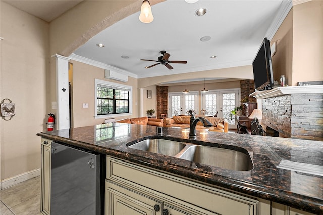 4001 Roswell St, Dallas, TX 75219 - kitchen featuring a wall unit AC, french doors, a sink, cream cabinetry, and a fireplace