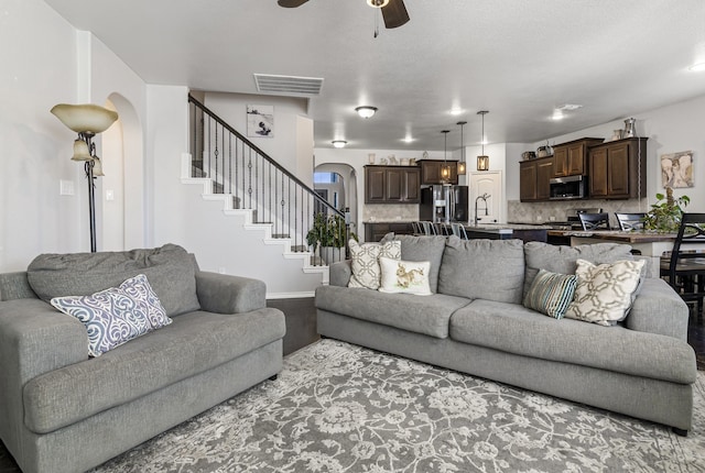 1753 Rio Penasco Rd, Fort Worth, TX 76052 - living area with arched walkways, ceiling fan, and stairway