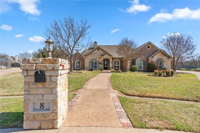 8 Republic Dr, Waco, TX 76708 - view of front facade featuring a front yard, a chimney, and brick siding