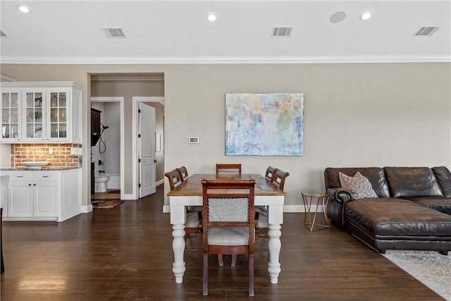 dining area featuring visible vents, dark wood-style floors, and crown molding