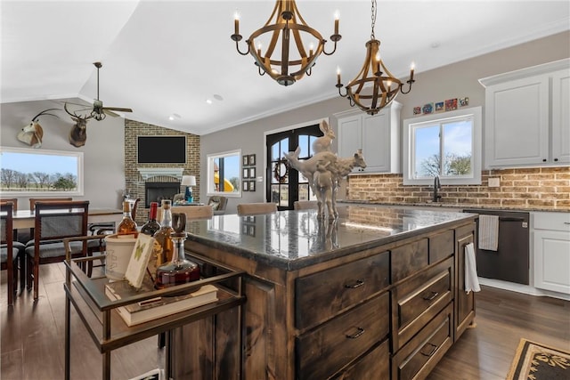 kitchen with dark wood-style floors, a fireplace, vaulted ceiling, white cabinets, and dishwasher