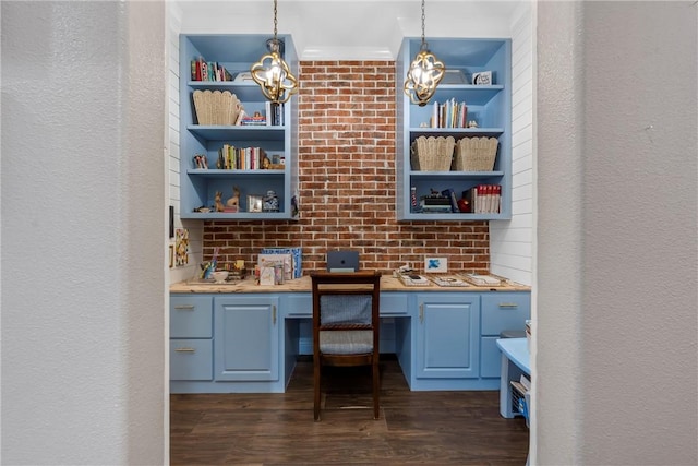 home office with built in study area, dark wood-type flooring, and a textured wall