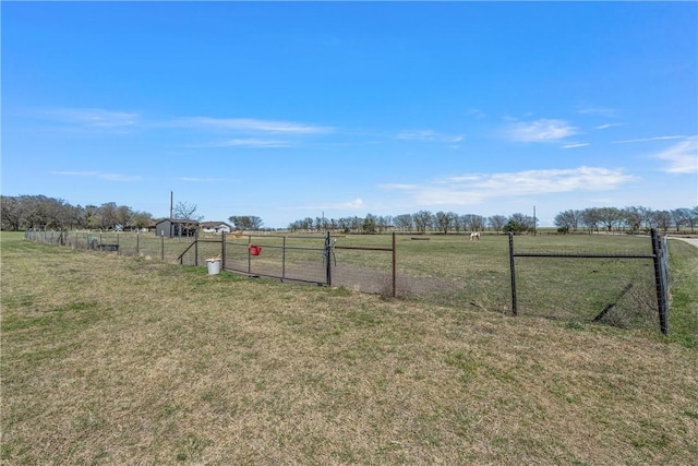 view of yard featuring a gate, a rural view, and fence