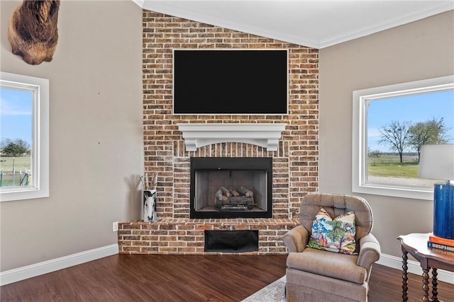 living room with vaulted ceiling, a brick fireplace, and plenty of natural light