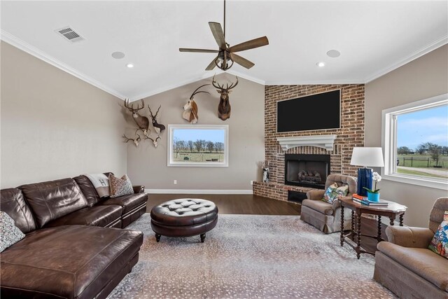 living room featuring a healthy amount of sunlight, crown molding, and wood finished floors