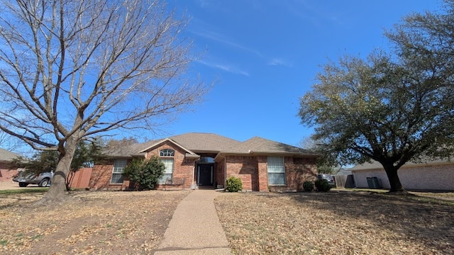 single story home featuring brick siding and a shingled roof