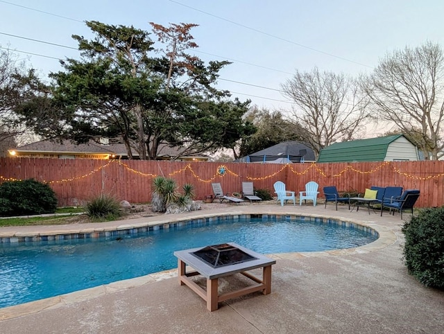 view of pool with a fenced backyard, a fenced in pool, a fire pit, and a patio