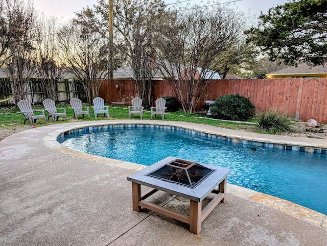 view of swimming pool featuring a patio area, a fenced in pool, an outdoor fire pit, and fence