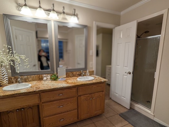 full bathroom with tile patterned flooring, ornamental molding, a shower stall, and a sink