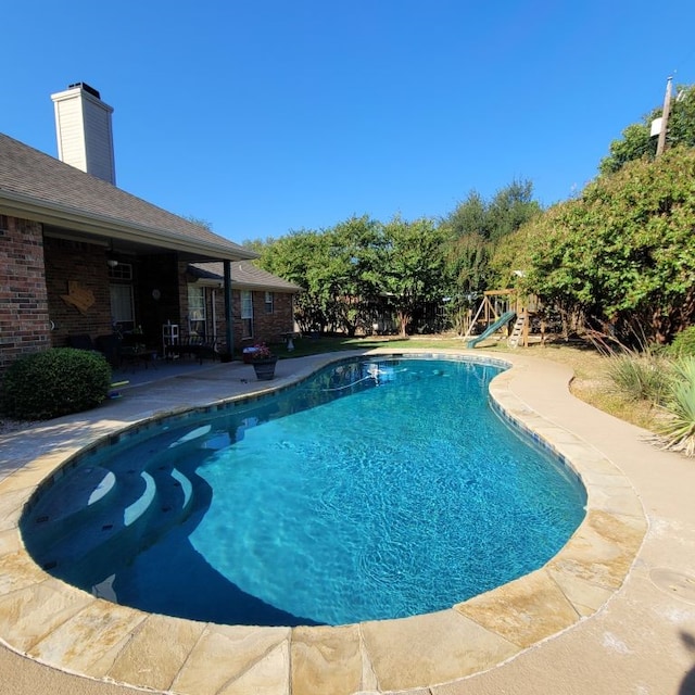pool with a patio and a playground
