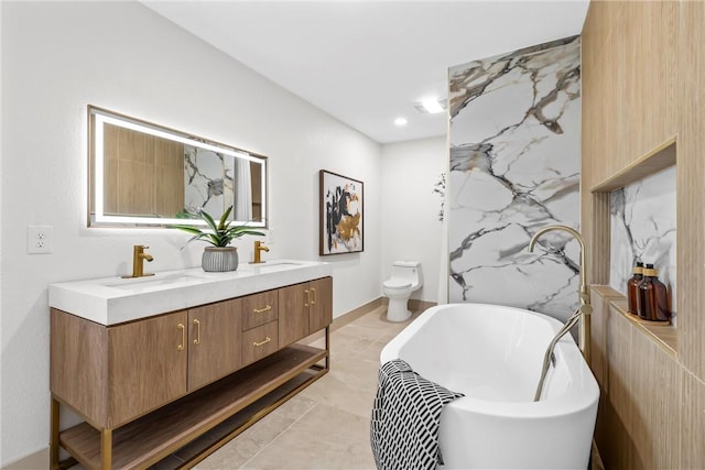 2211 Morrow Ave, Waco, TX 76707 - full bath featuring double vanity, a freestanding tub, toilet, and marble finish floors