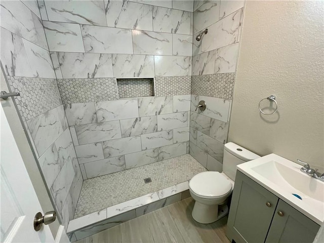 310 N Lakeview Dr, Lacy Lakeview, TX 76705 - full bathroom with a tile shower, toilet, a textured wall, and vanity