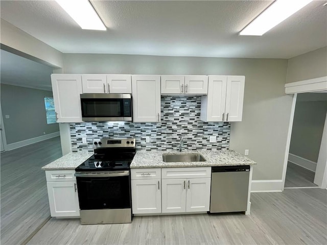 310 N Lakeview Dr, Lacy Lakeview, TX 76705 - kitchen with stainless steel appliances, a sink, baseboards, and decorative backsplash