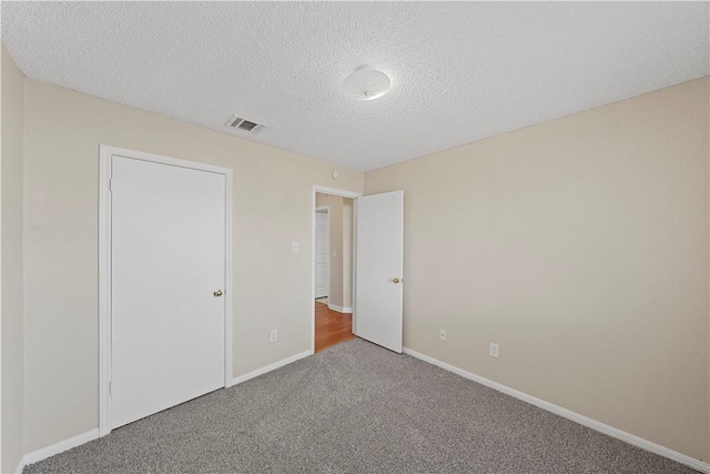 1901 Ruidoso Dr, Waco, TX 76712 - unfurnished bedroom with carpet floors, baseboards, and a textured ceiling