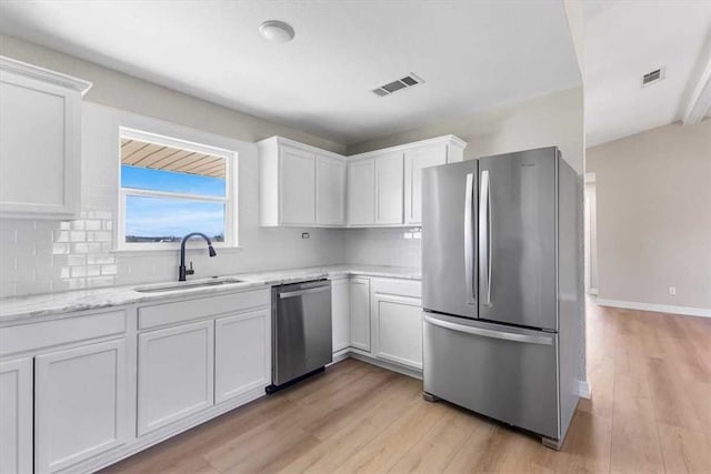 kitchen featuring visible vents, light wood-style flooring, a sink, appliances with stainless steel finishes, and white cabinetry
