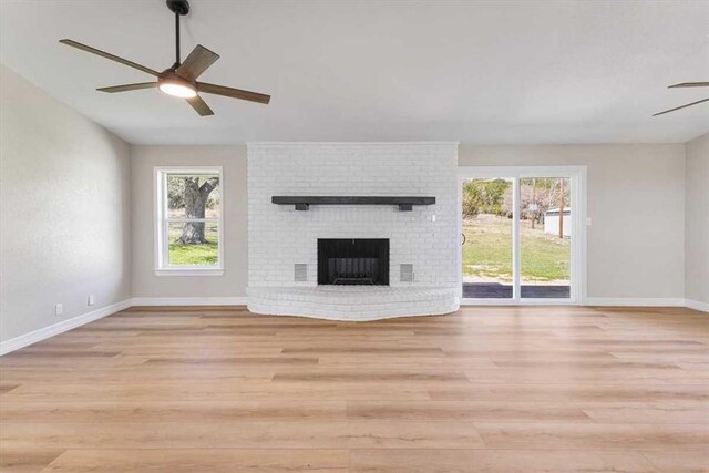unfurnished living room with plenty of natural light, a ceiling fan, and light wood finished floors