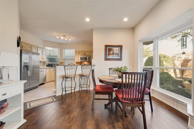 dining area with recessed lighting, a textured ceiling, and hardwood / wood-style flooring