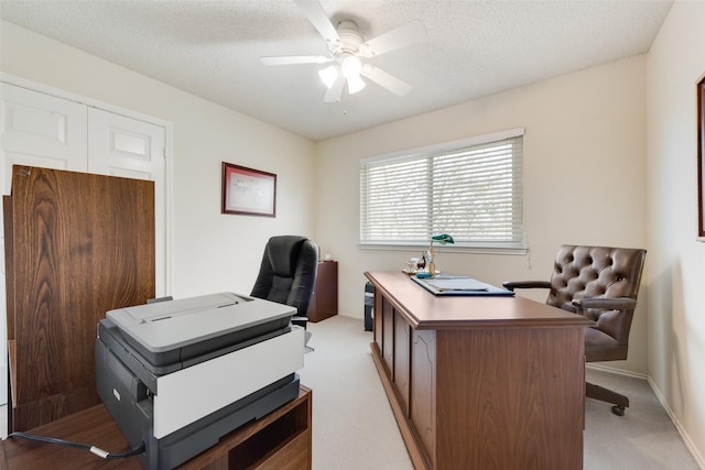 office space with a textured ceiling, light carpet, and ceiling fan