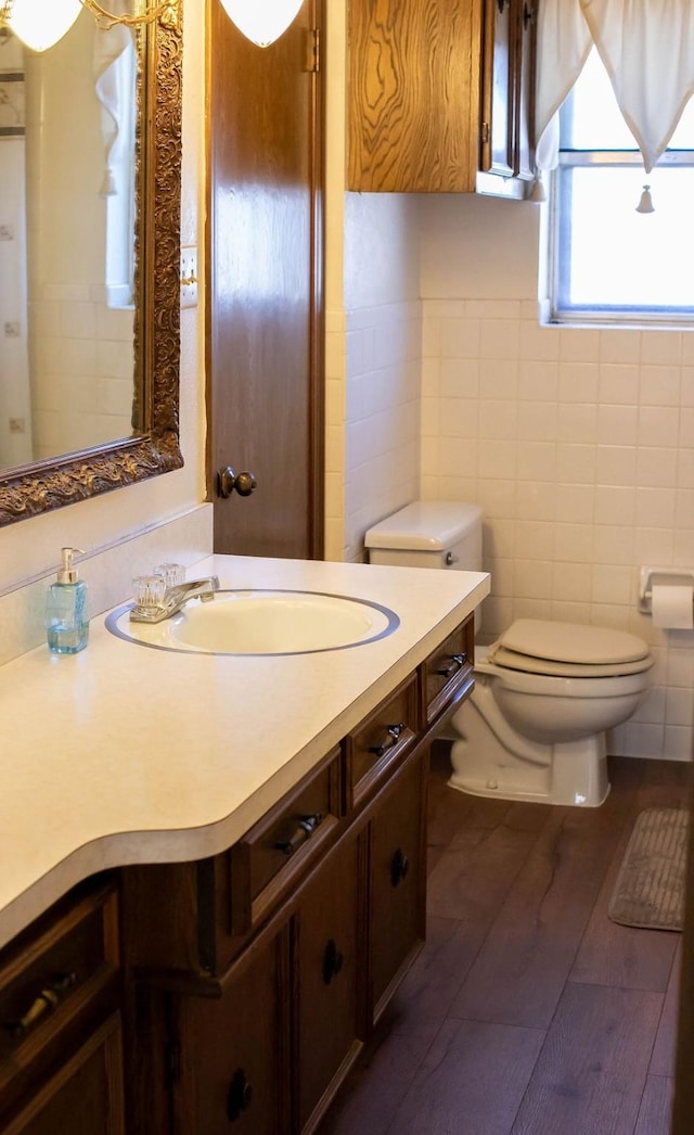 5204 Mansfield Rd, Arlington, TX 76017 - bathroom featuring toilet, tile walls, wood finished floors, and vanity
