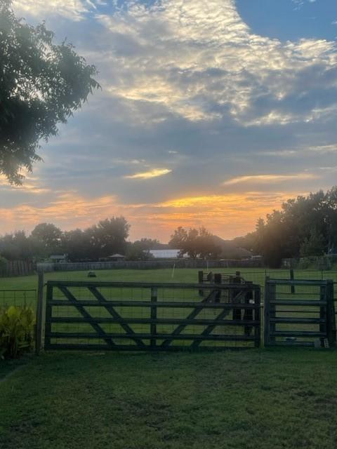 5204 Mansfield Rd, Arlington, TX 76017 - view of gate with a rural view, a lawn, and fence