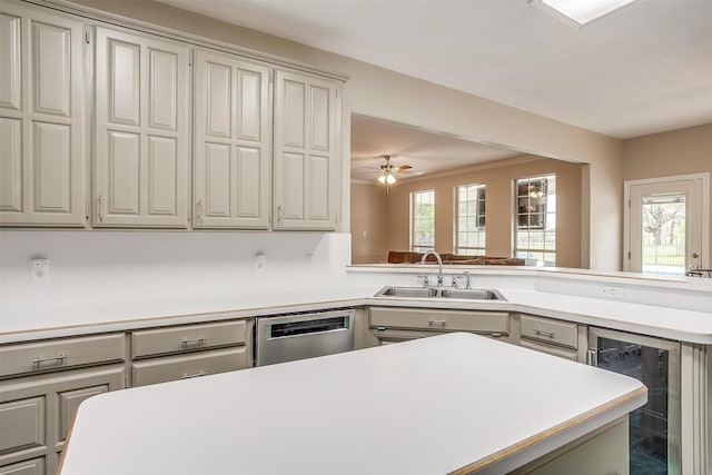 2212 Summit Dr, Burleson, TX 76028 - kitchen with stainless steel dishwasher, a sink, light countertops, beverage cooler, and gray cabinetry