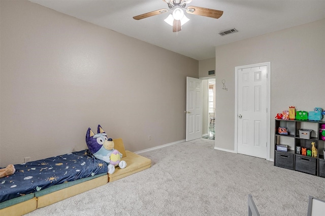carpeted bedroom with visible vents, a ceiling fan, and baseboards