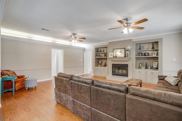 2212 Summit Dr, Burleson, TX 76028 - living room with a ceiling fan, light wood-style floors, a brick fireplace, ornamental molding, and built in shelves