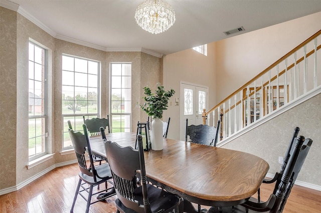 dining space featuring a wealth of natural light, light wood finished floors, visible vents, and an inviting chandelier