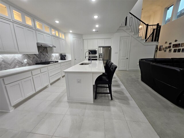 2856 Chester Dr, Celina, TX 75009 - kitchen featuring decorative backsplash, a sink, white cabinets, a kitchen island with sink, and appliances with stainless steel finishes